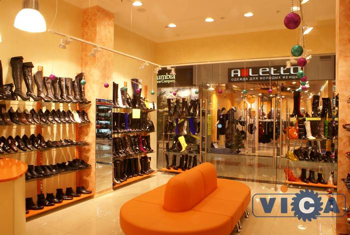 Креативный дизайн магазина обуви превосходно дополняет банкетка оранжевого цвета.