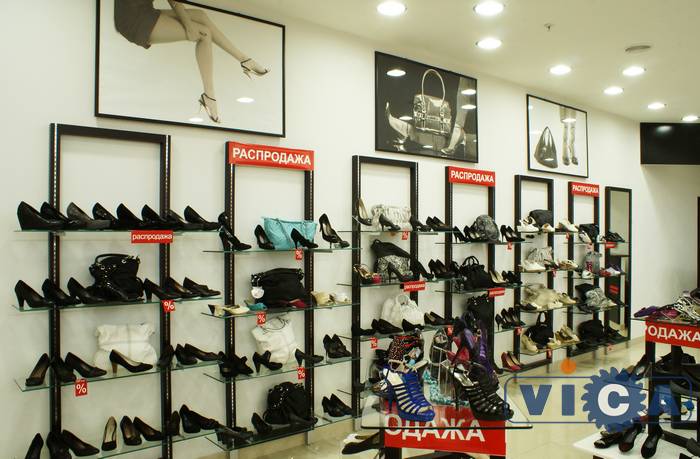 Постеры над торговым оборудованием эстетично завершают интерьер магазина обуви.