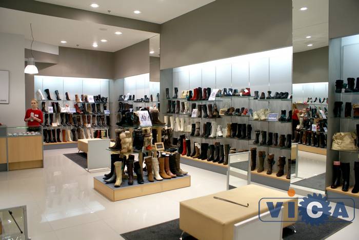 Интерьер обувного магазина выполнен в светло-серых тонах с элементами отделки из ДСП и массива дерева цвета Светлый Бук.