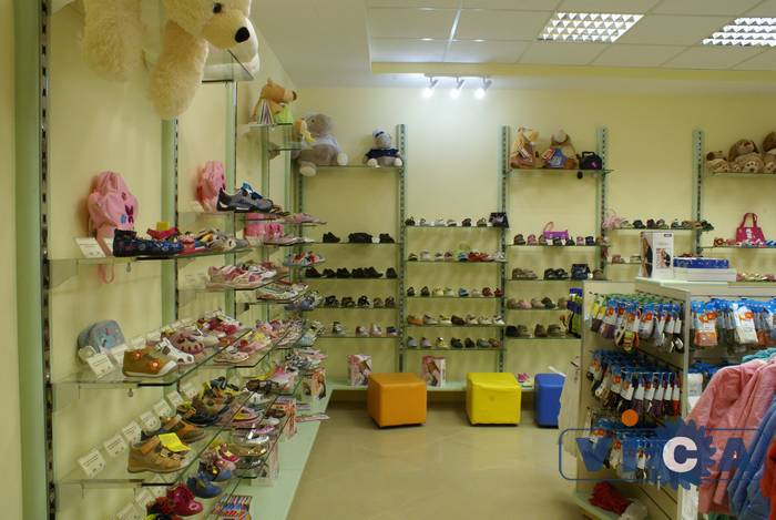 Оборудование для магазина детской обуви представлено настенными стойками &quot;Глобал&quot; с декором  салатового цвета.